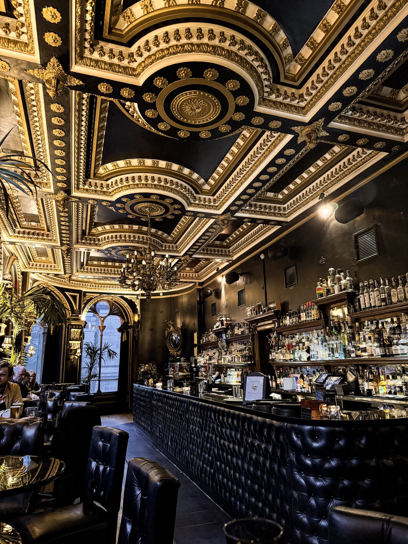 Ornate gold and black ceiling detail in a bar