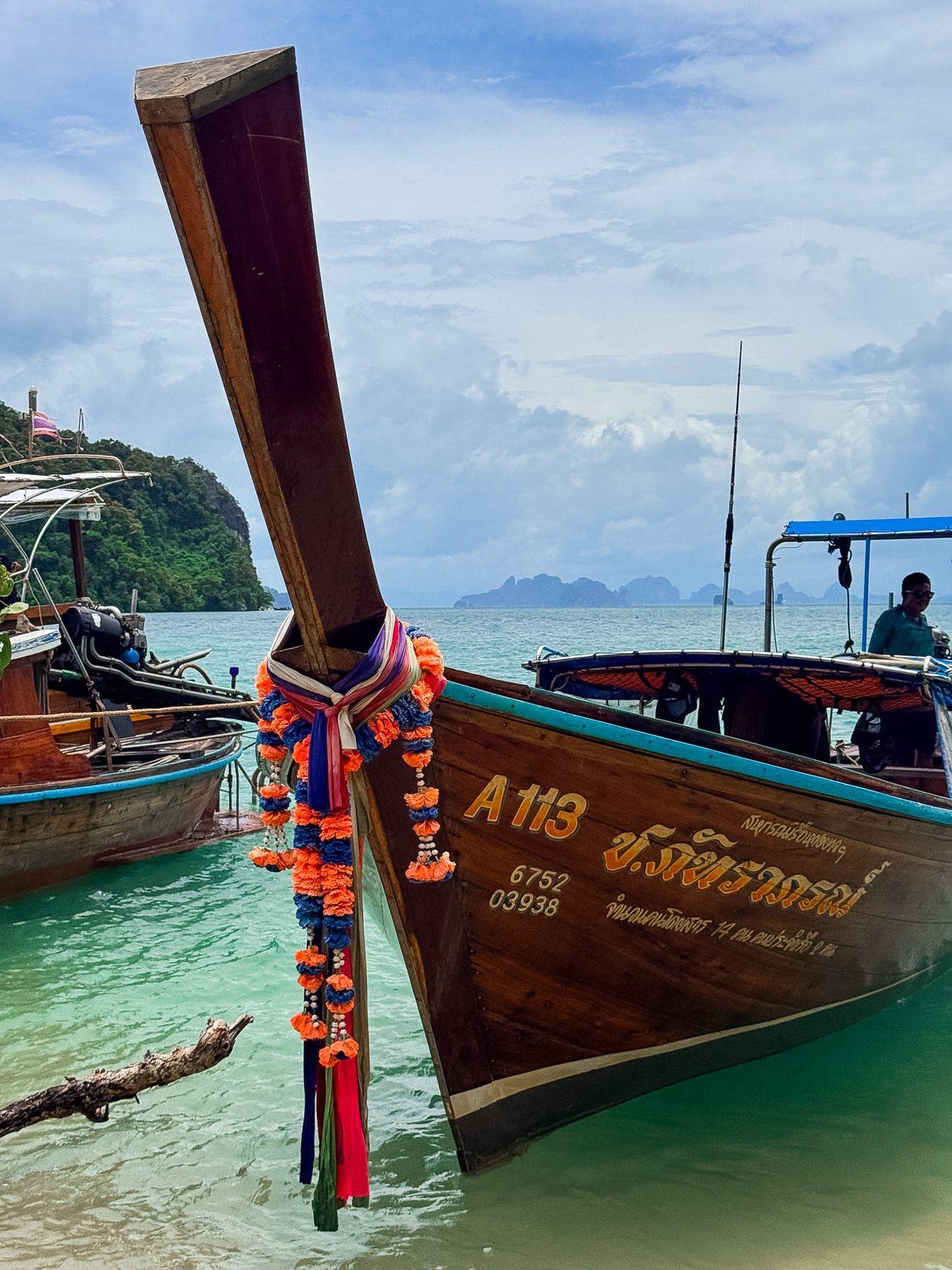 Bow of a traditional longtail boat decorated with garlands, Thailand